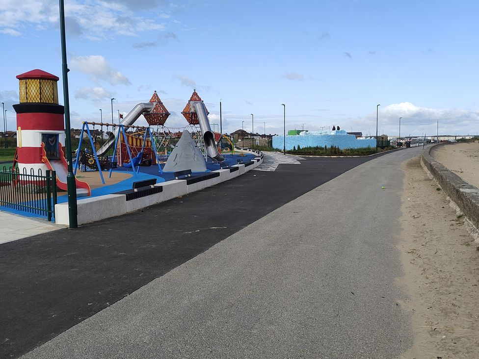 A playground with a lighthouse, swings, and slides at Sands Retreat in Redcar