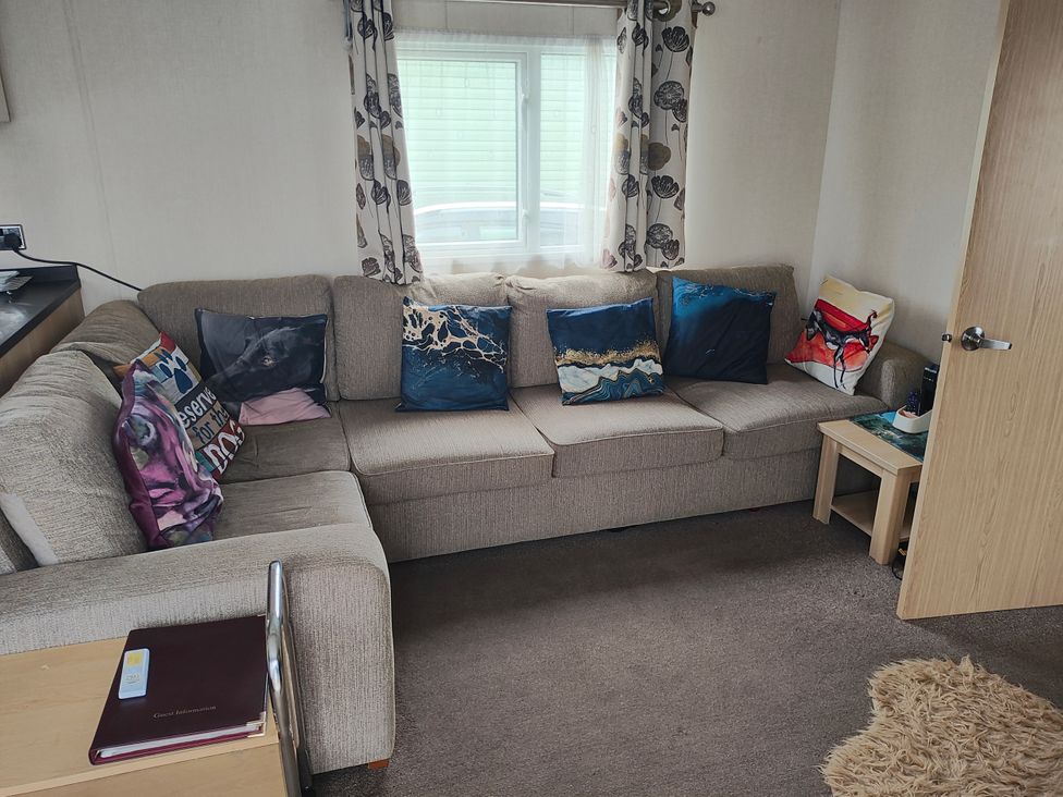 A living room with a sofa and cushions at Sands Retreat in Redcar