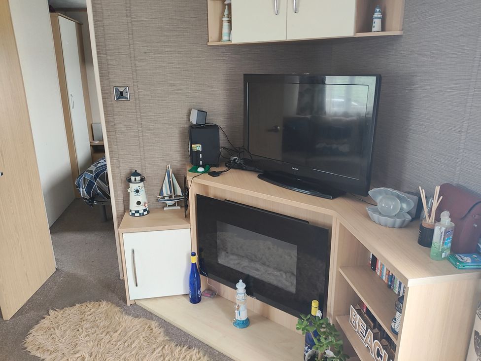 A living room with a television and bookshelves at Sands Retreat in Redcar