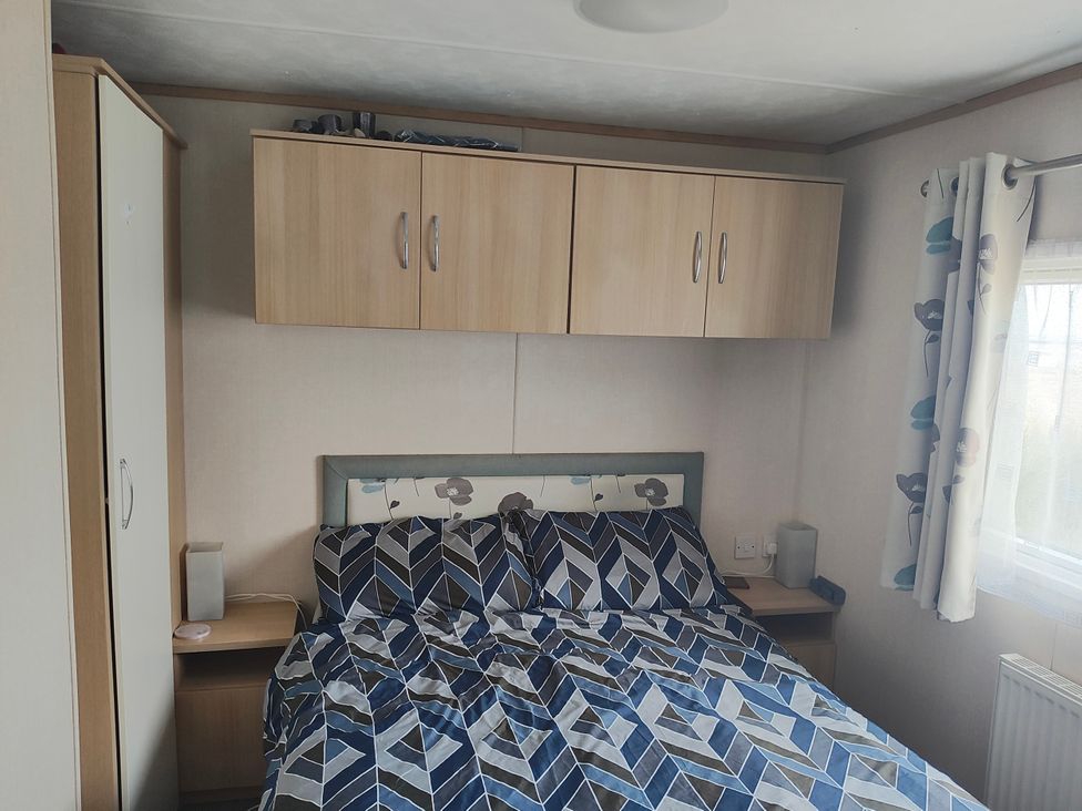 A bedroom with a bed and wardrobe at Sands Retreat in Redcar