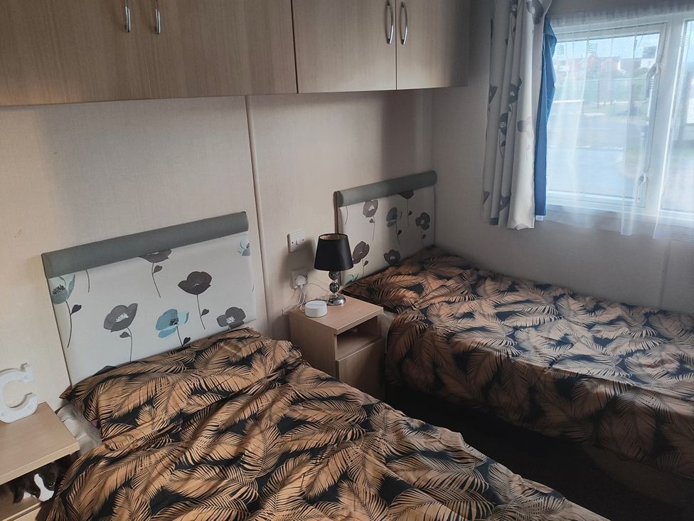 A bedroom with two beds and bedside tables at Sands Retreat in Redcar