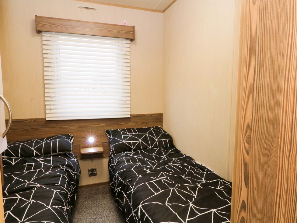 A bedroom with two single beds and a window at F2