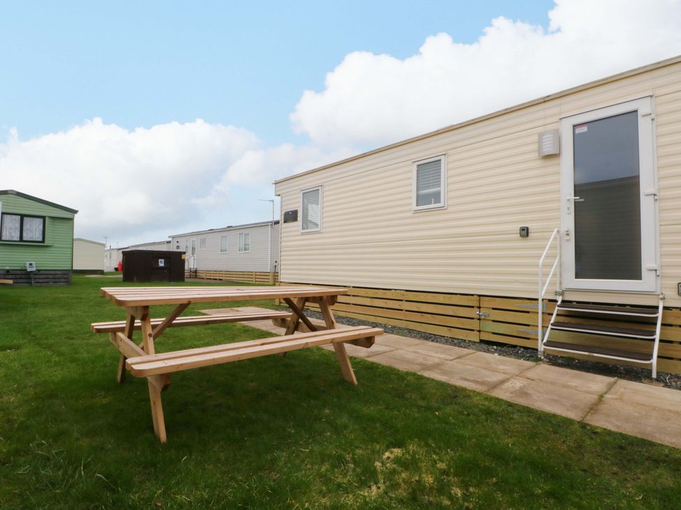 An outdoor area with a mobile home and a table at F2