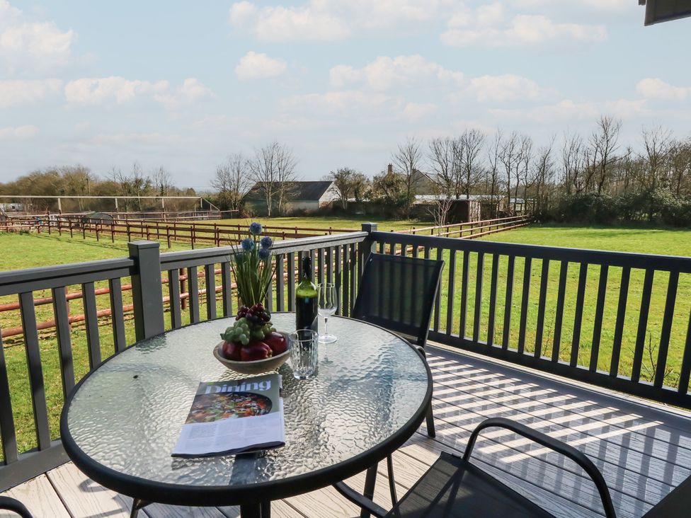 A table with a bottle and glass on a patio at Grass Roots in 