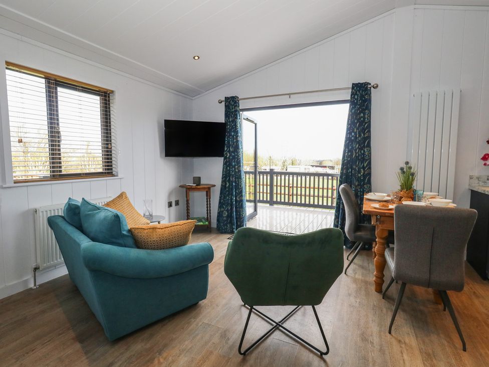 A living room with a sofa and dining table at Grass Roots