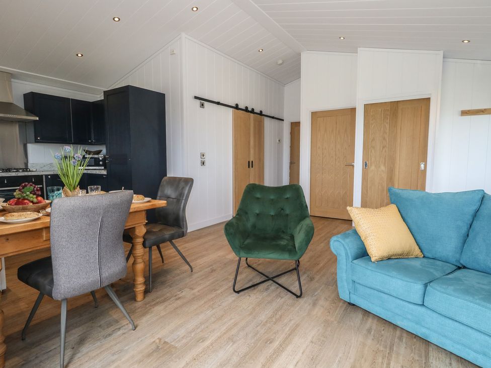 A living room with a dining area and kitchen at Grass Roots 
