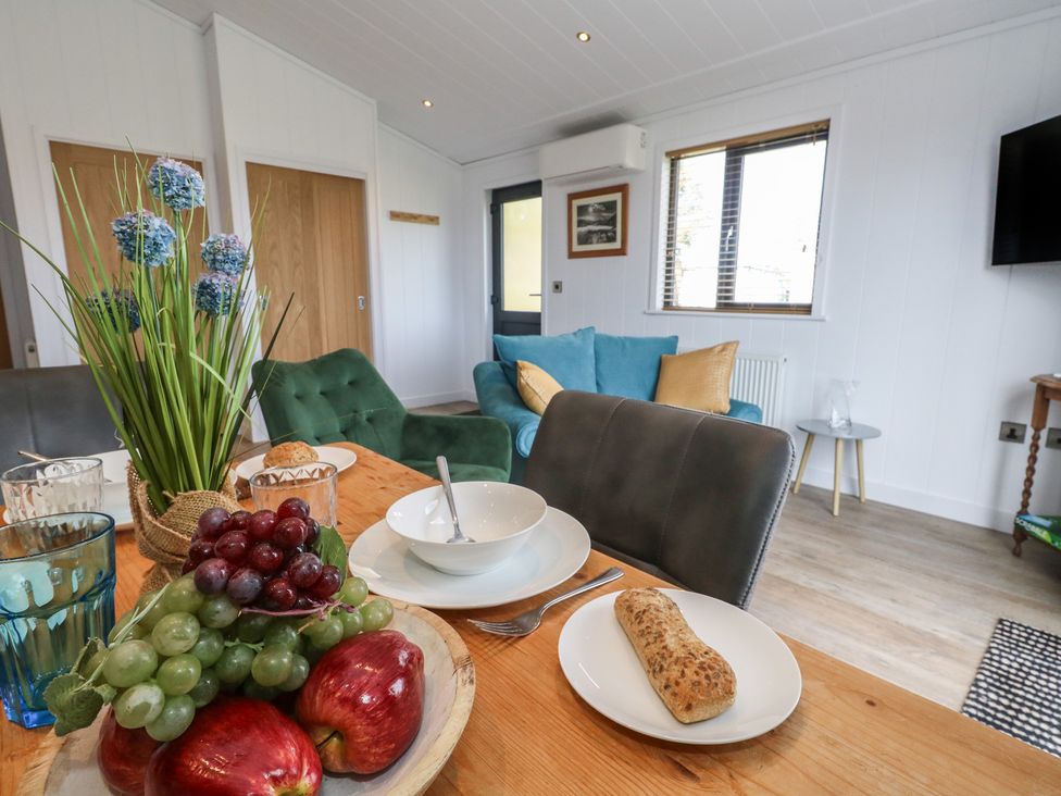 A dining room with a table set and living area in view at Grass Roots