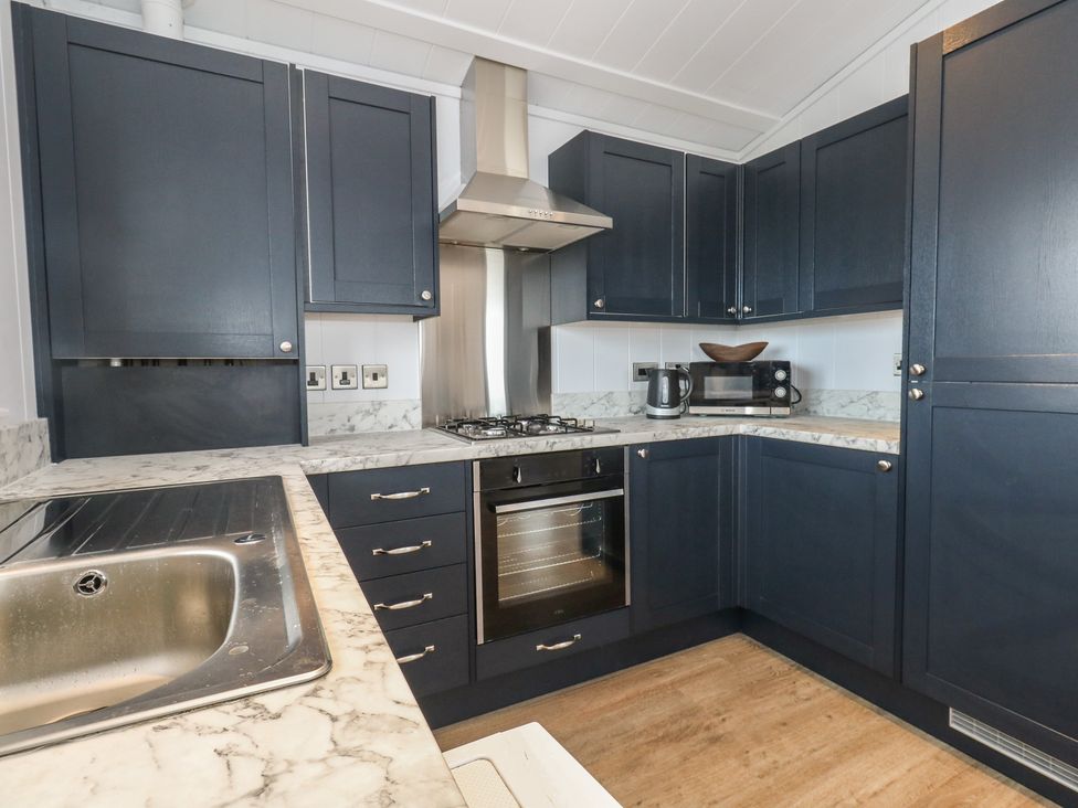 A kitchen with dark cabinets and stainless steel appliances at Grass Roots 