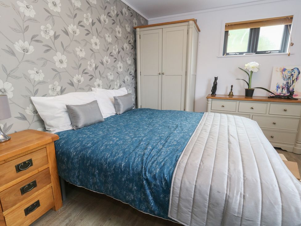 A bedroom with a bed and wardrobe at Grass Roots