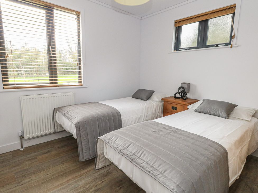 A bedroom with two beds and a bedside table at Grass Roots