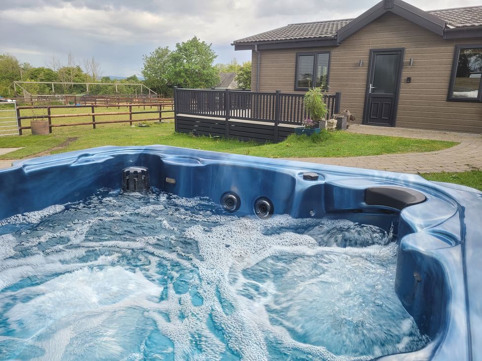 A hot tub with bubbles in an outdoor area at Grass Roots in Henstridge near Stalbridge