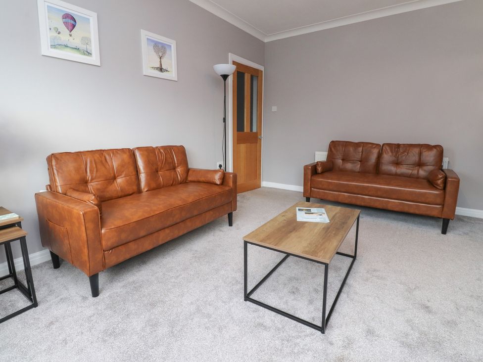 A living room with brown sofas and a coffee table at Flat 6 in Lytham St. Annes