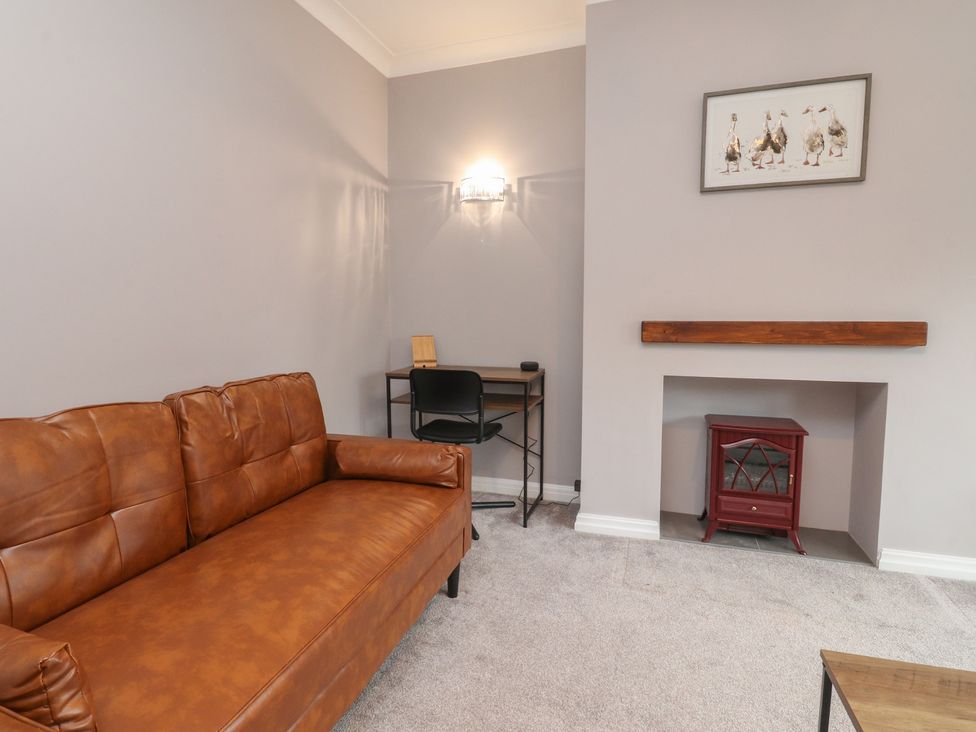 A living room with a sofa and desk at Flat 6 in Lytham St. Annes