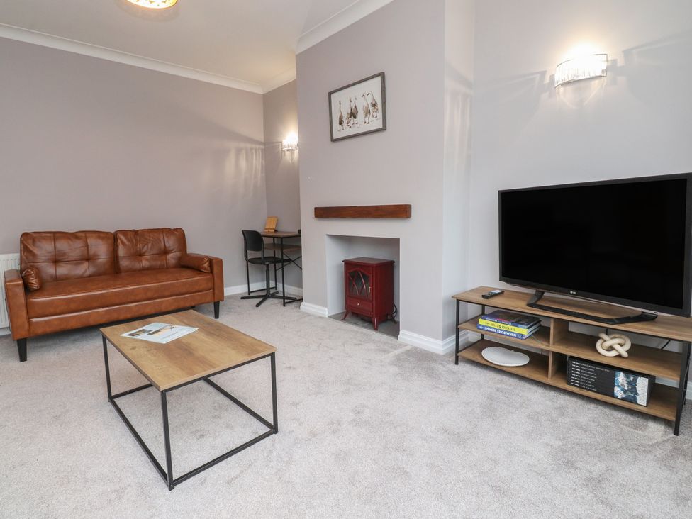 A living room with a sofa and television at Flat 6 in Lytham St. Annes