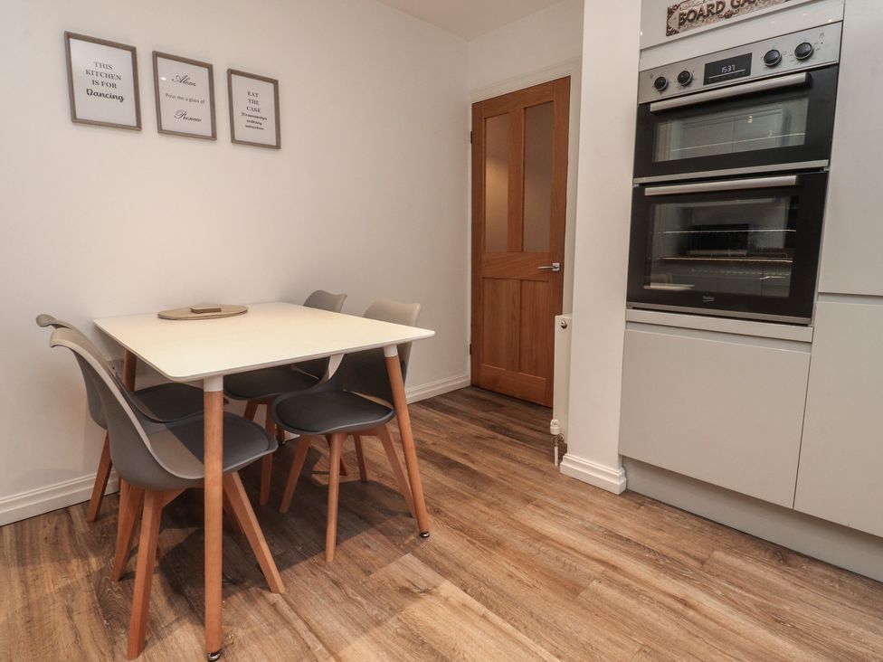 A kitchen with a dining table and chairs along with an oven at Flat 6 in Lytham St. Annes