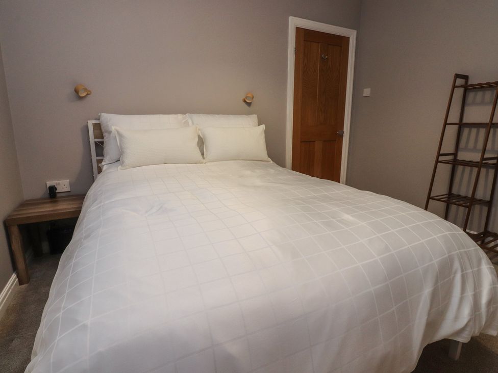 A bedroom with a bed and a shelf at Flat 6 in Lytham St. Annes