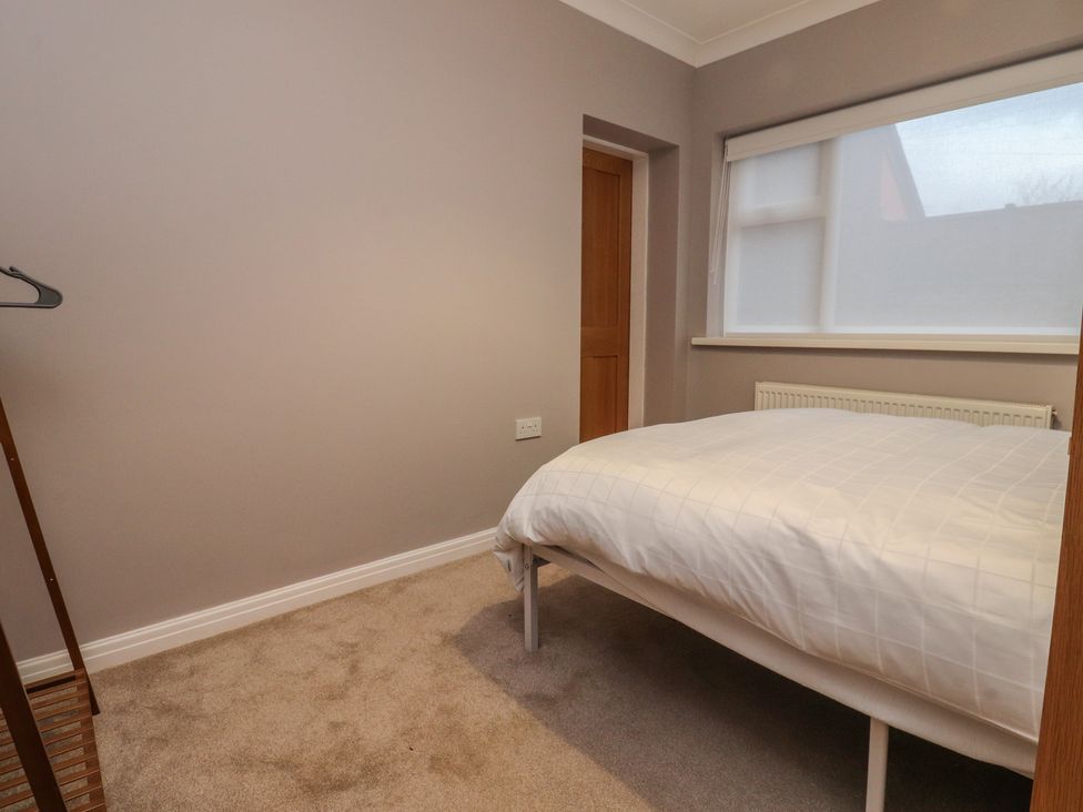 A bedroom with a bed and a hanger at Flat 6 in Lytham St. Annes