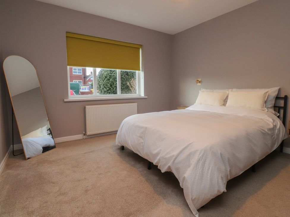 A bedroom with a bed and a mirror at Flat 6 in Lytham St. Annes