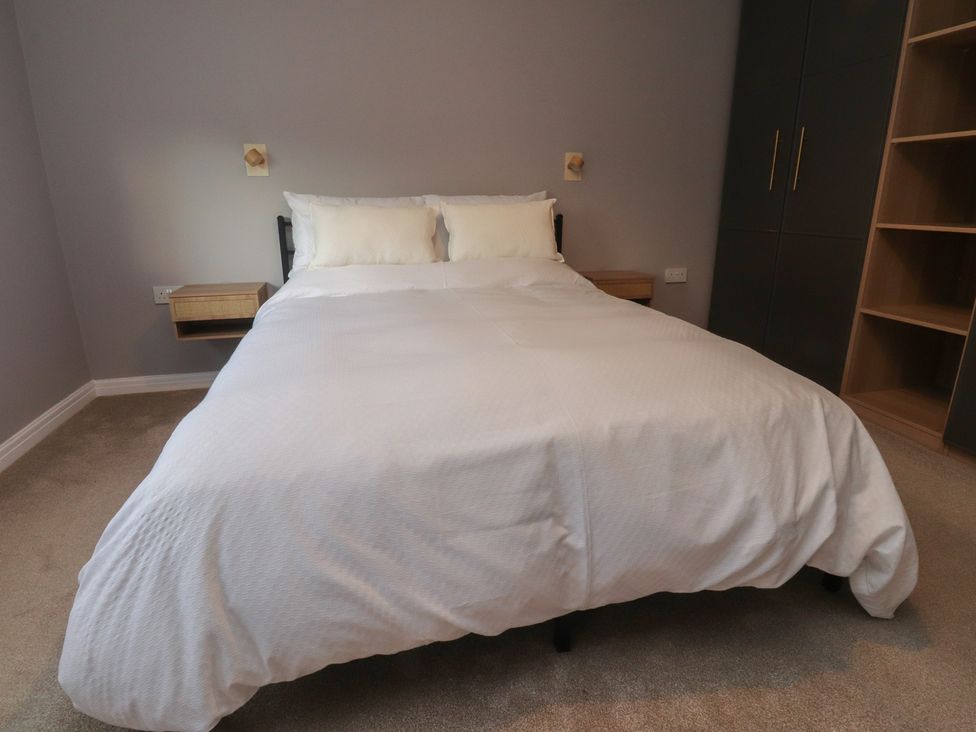 A bedroom with a bed and nightstand at Flat 6 in Lytham St. Annes