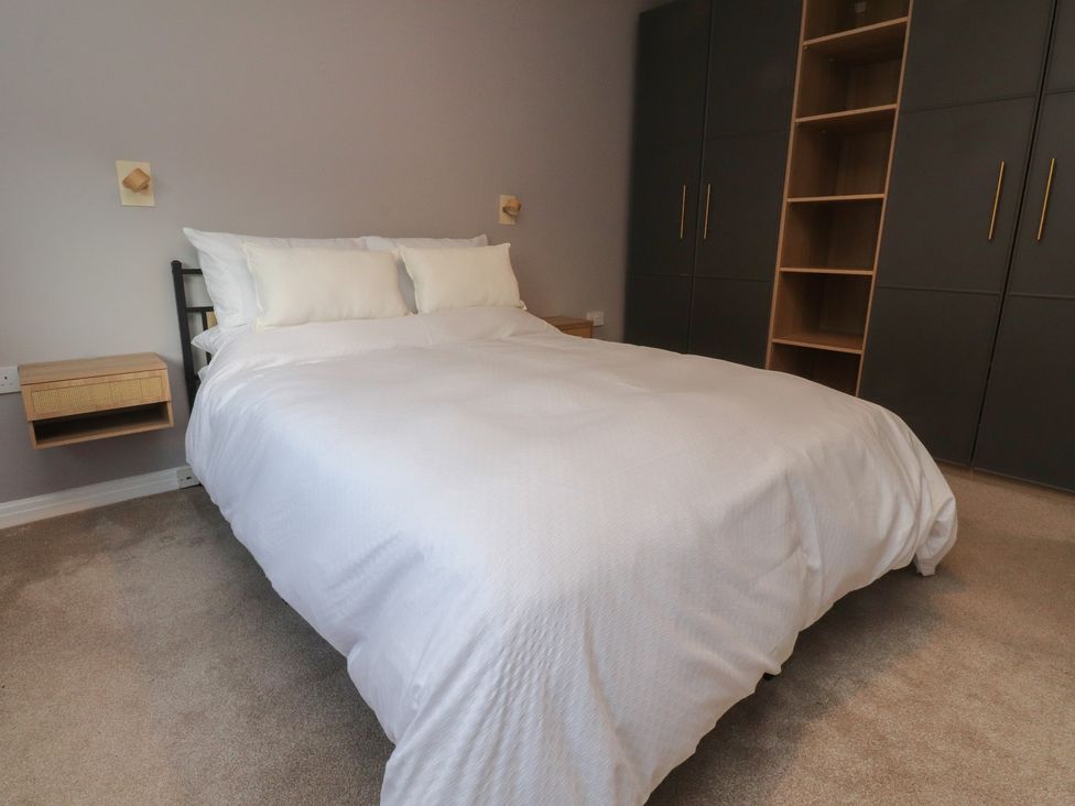 A bedroom with a bed and storage units at Flat 6 in Lytham St. Annes