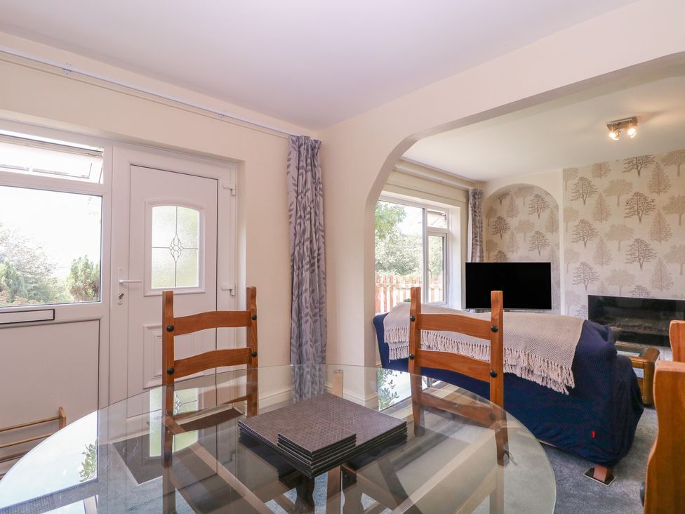 A dining room with a glass table and chairs at 24 Cefn Court Newport