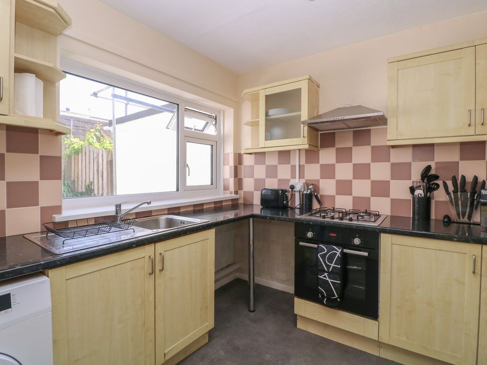 A kitchen with cabinets and appliances at 24 Cefn Court Newport