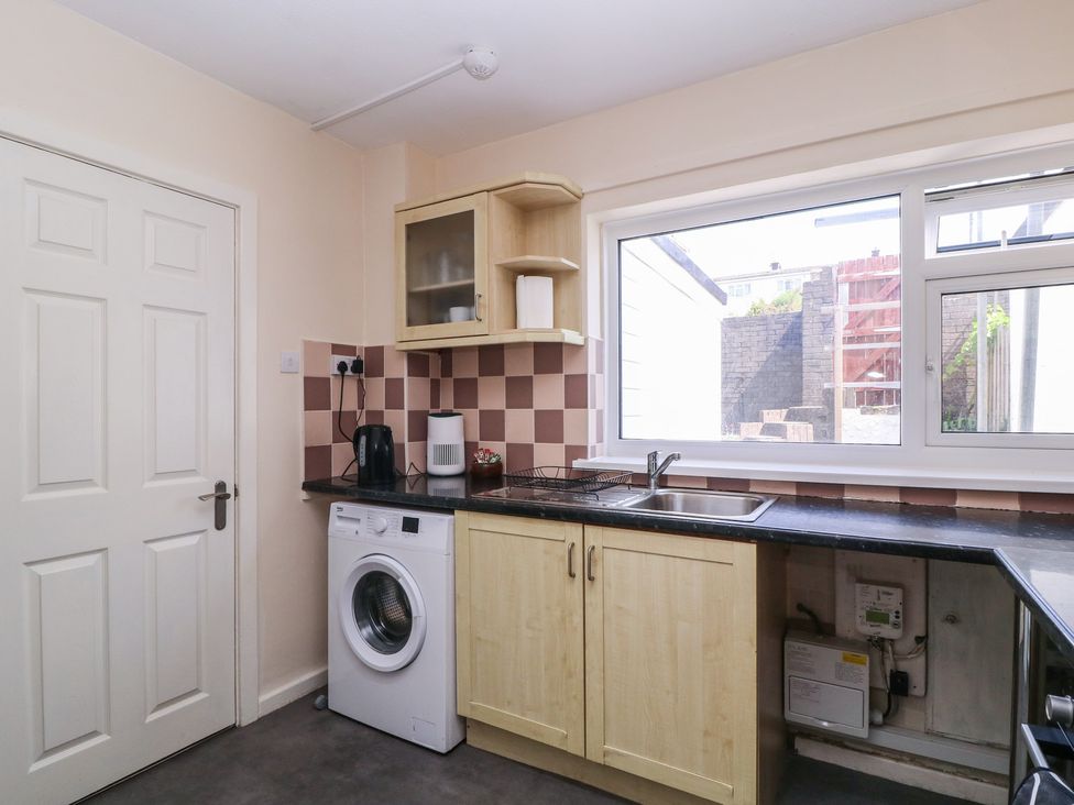 A kitchen with a sink and washing machine at 24 Cefn Court Newport