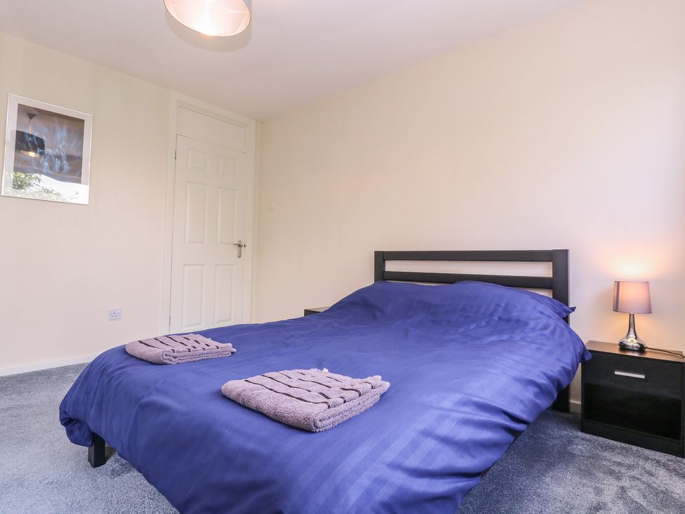 A bedroom with a bed and nightstand at 24 Cefn Court Newport