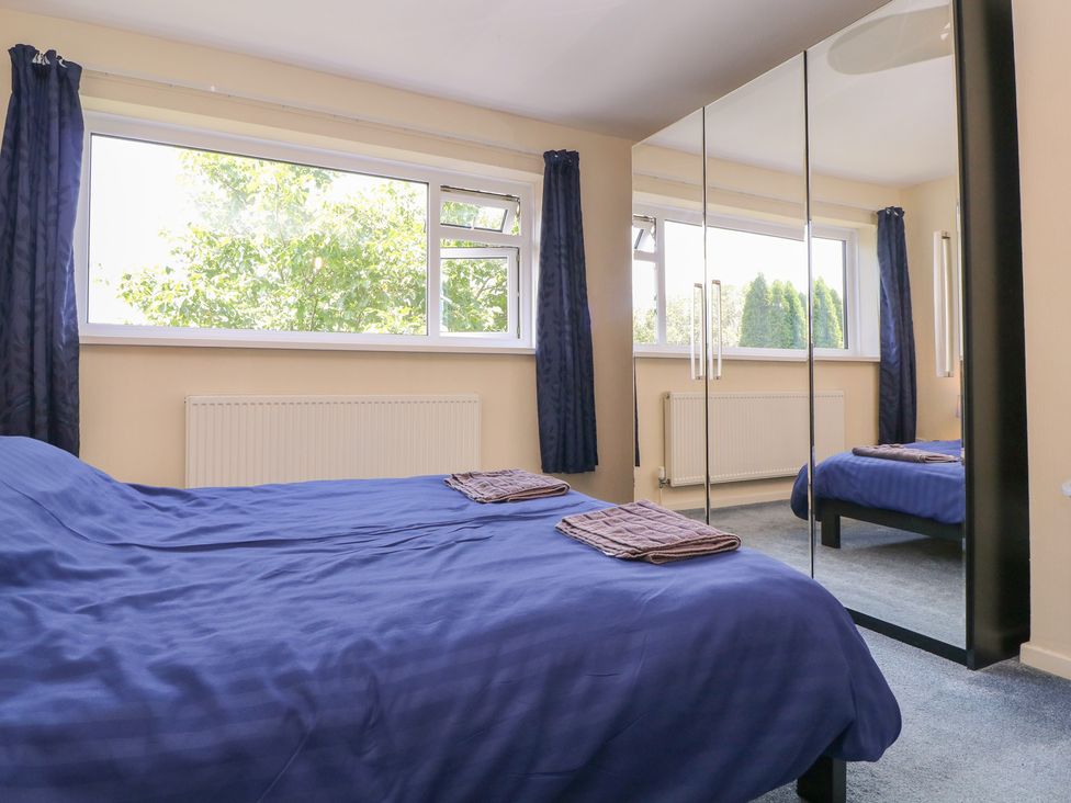 A bedroom with a bed and wardrobe at 24 Cefn Court Newport