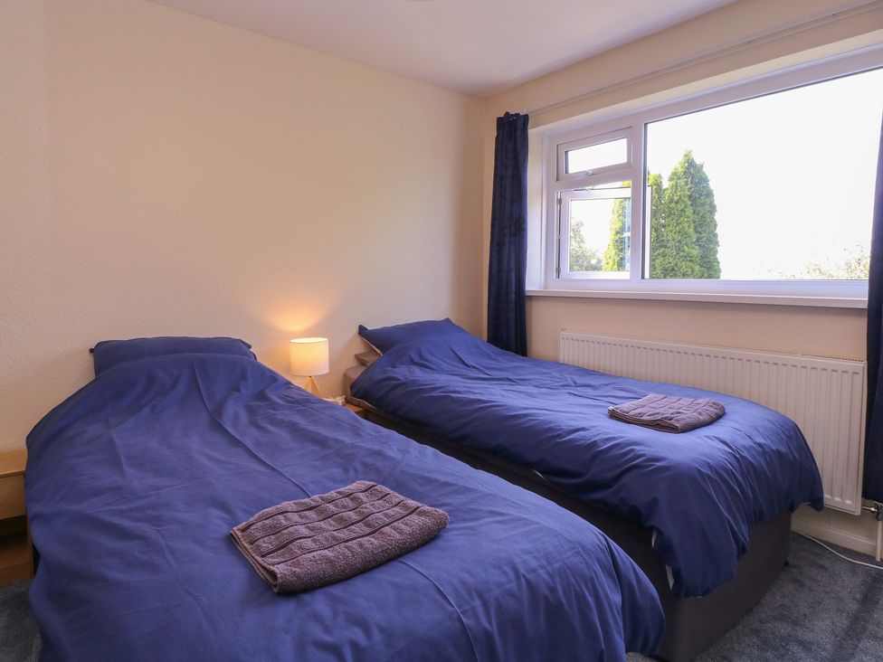 A bedroom with two single beds and a lamp at 24 Cefn Court in Newport