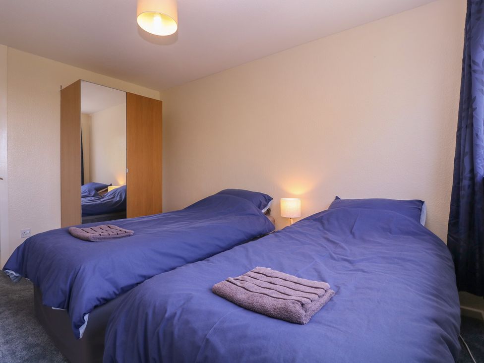 A bedroom with two beds and a wardrobe at 24 Cefn Court Newport