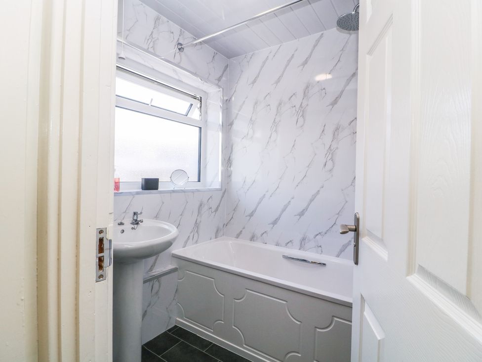 A bathroom featuring a bath tub and sink at 24 Cefn Court Newport