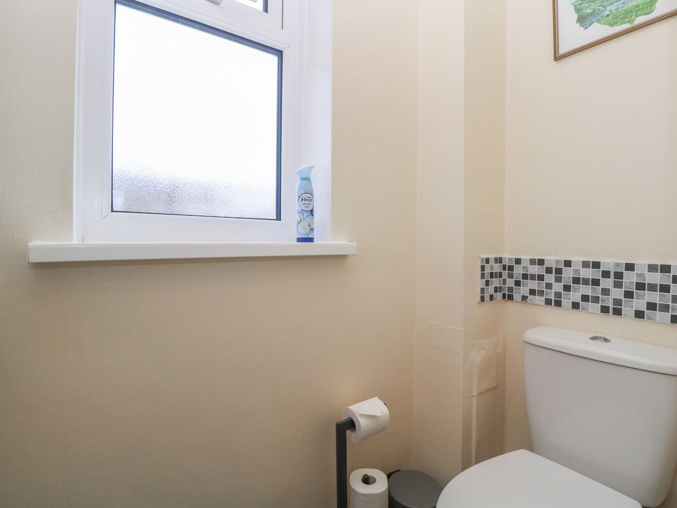 A bathroom with a toilet and window at 24 Cefn Court in Newport