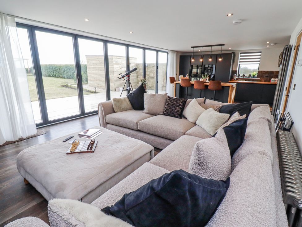 A living room with a sofa and telescope at The Joiners Cottage in Birling near Warkworth