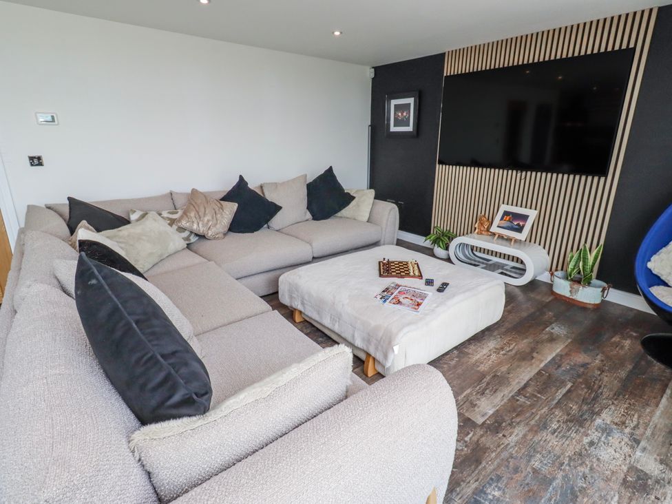 A living room with a sofa and TV at The Joiners Cottage Birling near Warkworth