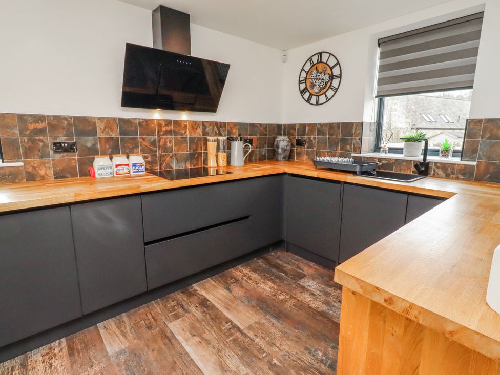 A kitchen with cabinets and a sink at The Joiners Cottage in Birling near Warkworth