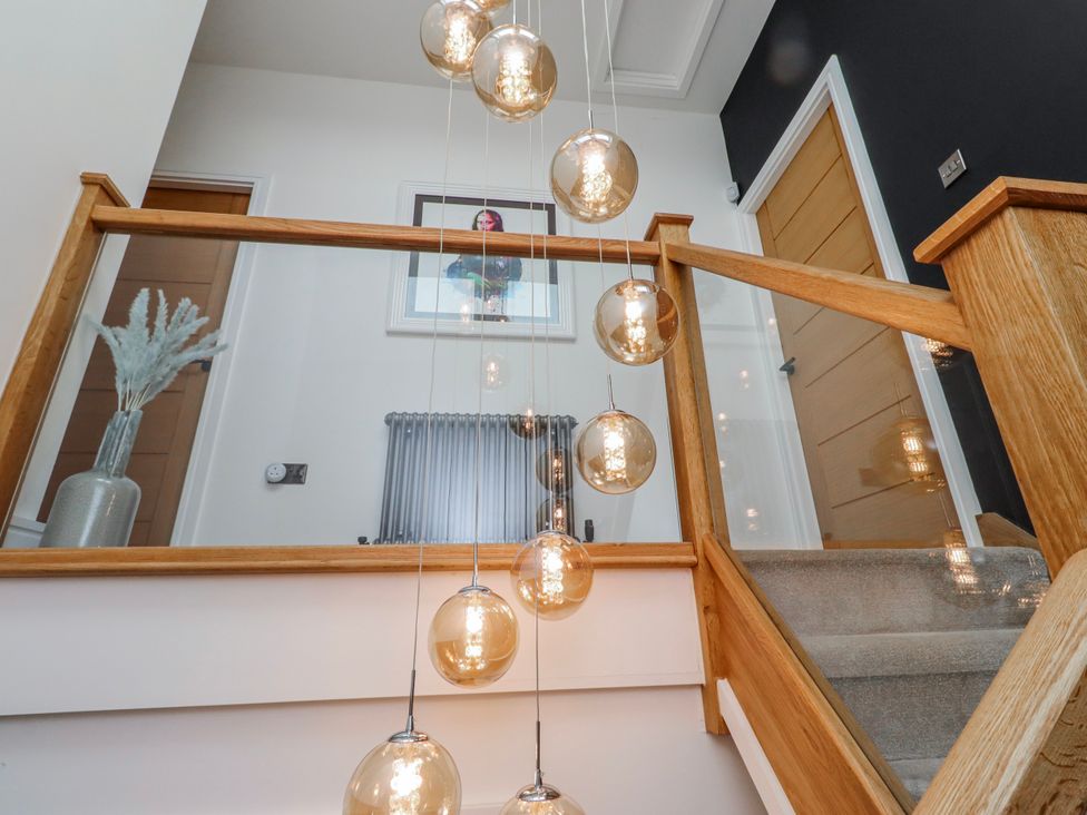 A staircase with light fixtures and a handrail at The Joiners Cottage Birling near Warkworth