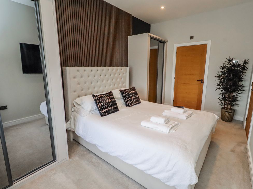 A bedroom with a bed and decorative pillows at The Joiners Cottage Birling near Warkworth