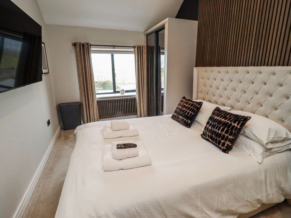 A bedroom with a bed and television at The Joiners Cottage in Birling near Warkworth