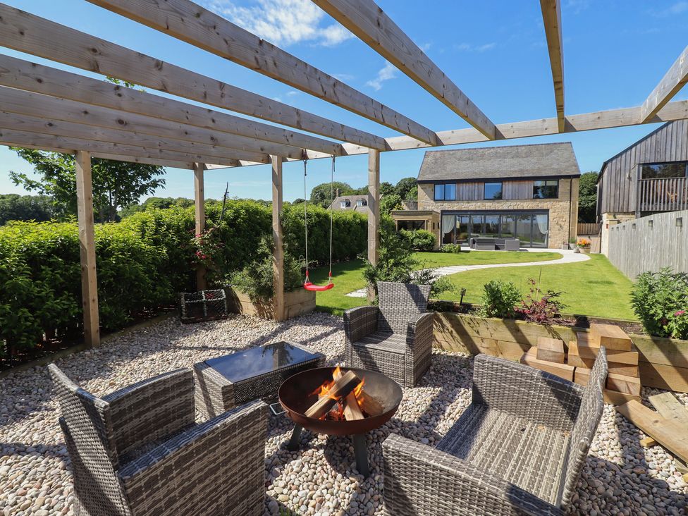 A garden with seating and a fire pit at The Joiners Cottage in Birling near Warkworth