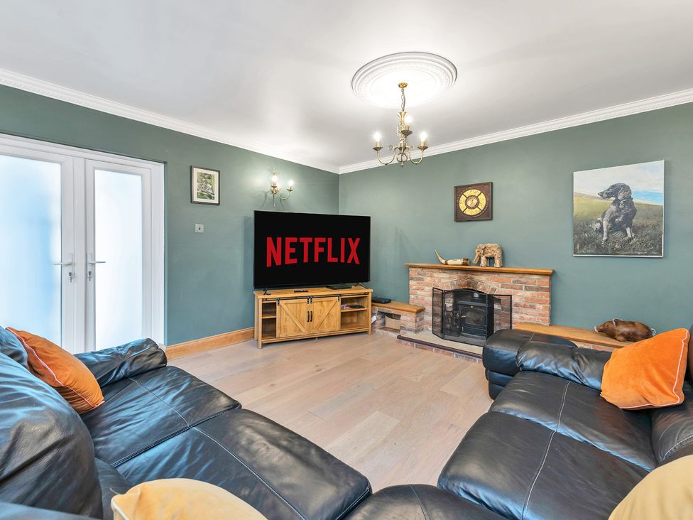 A living room with a television and fireplace at Oldfields