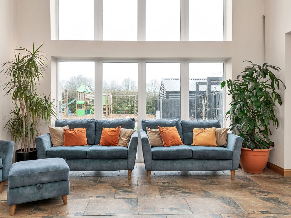 A living room with sofas and a view of a playground at Oldfields