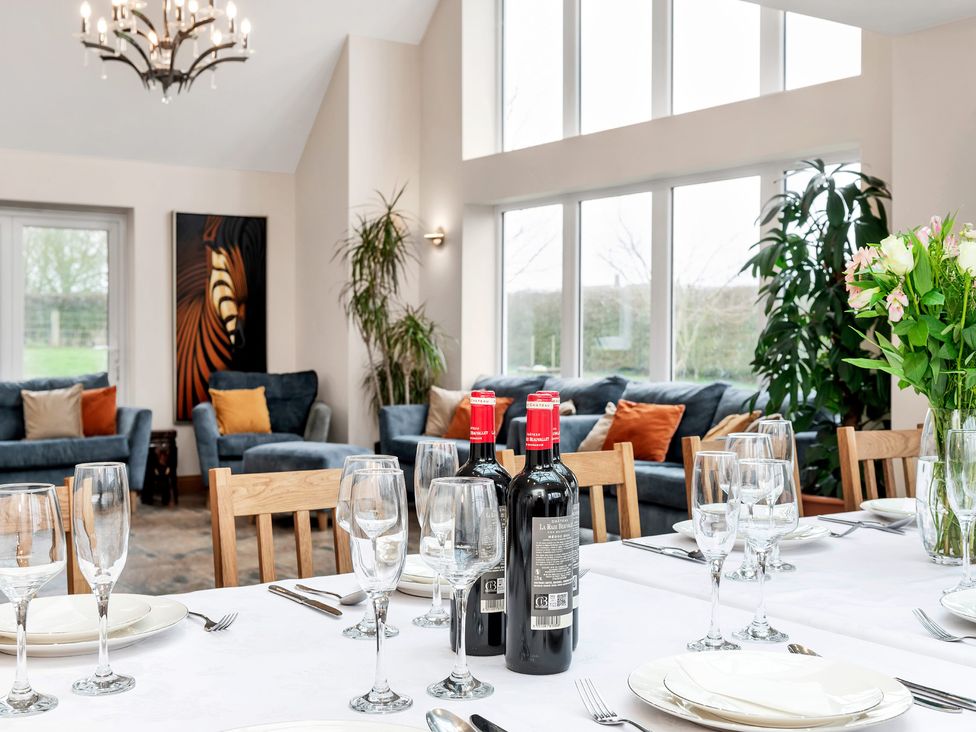 A dining room with a table set and wine bottles at Oldfields 