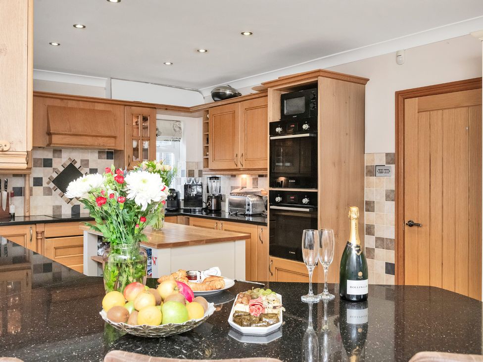 A kitchen with wooden cabinets and a fruit bowl at Oldfields