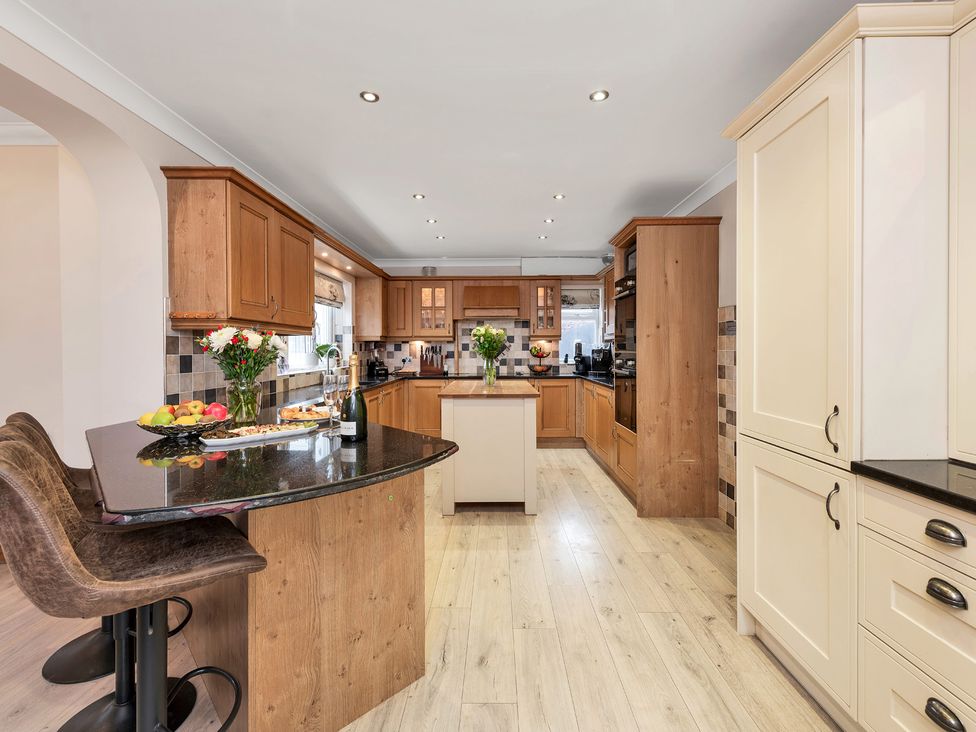A kitchen with an island and bar stools at Oldfields
