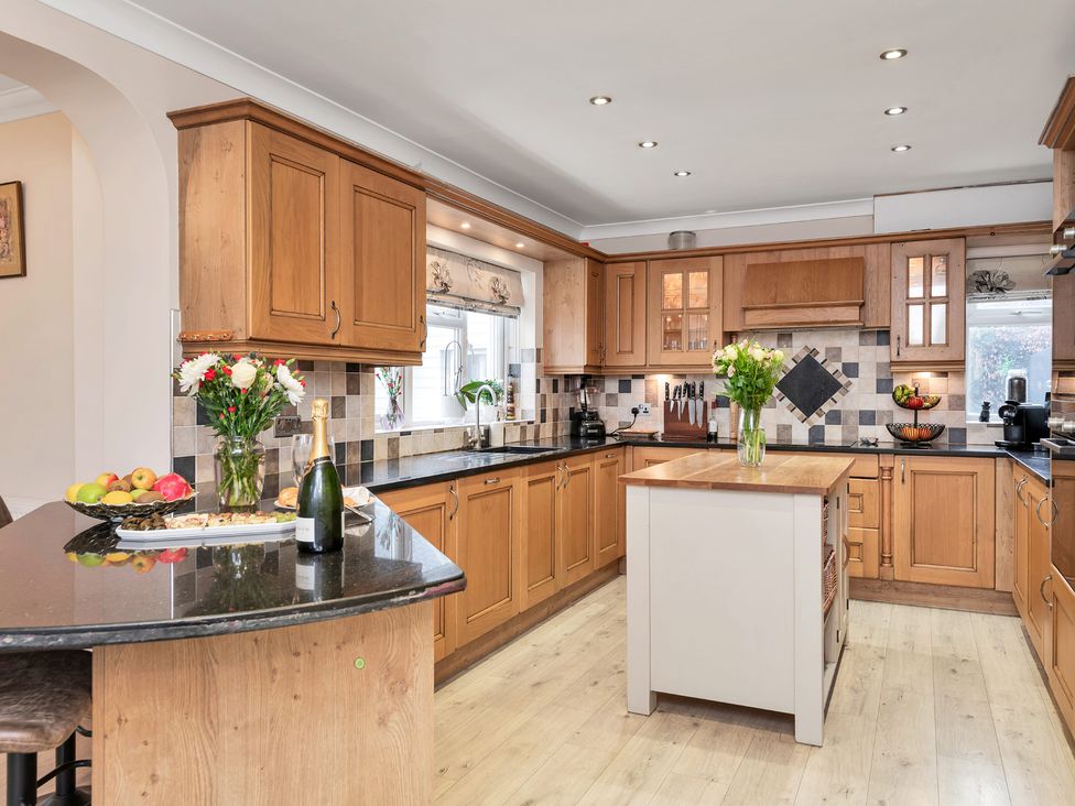 A kitchen with wooden cabinets and a central island at Oldfields