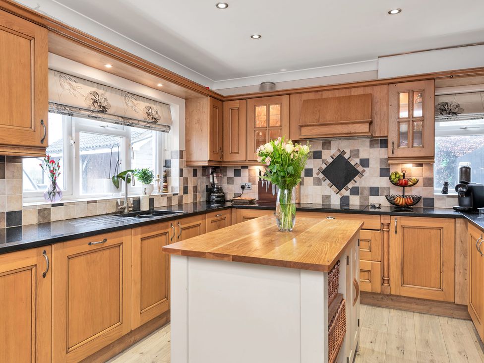 A kitchen with wooden cabinets and an island at Oldfields