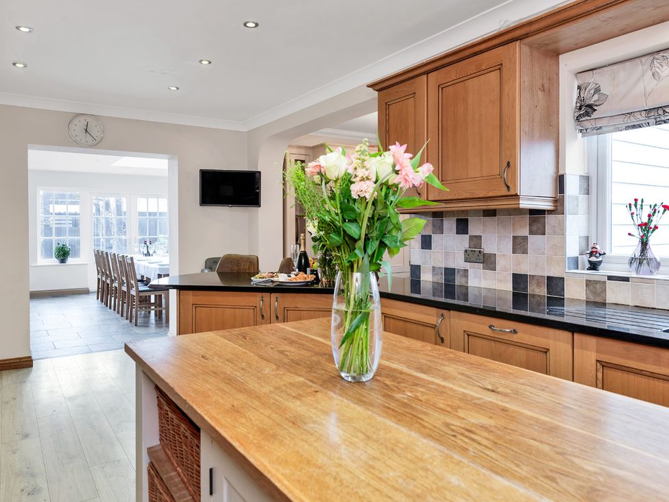 A kitchen with a vase of flowers on the table at Oldfields