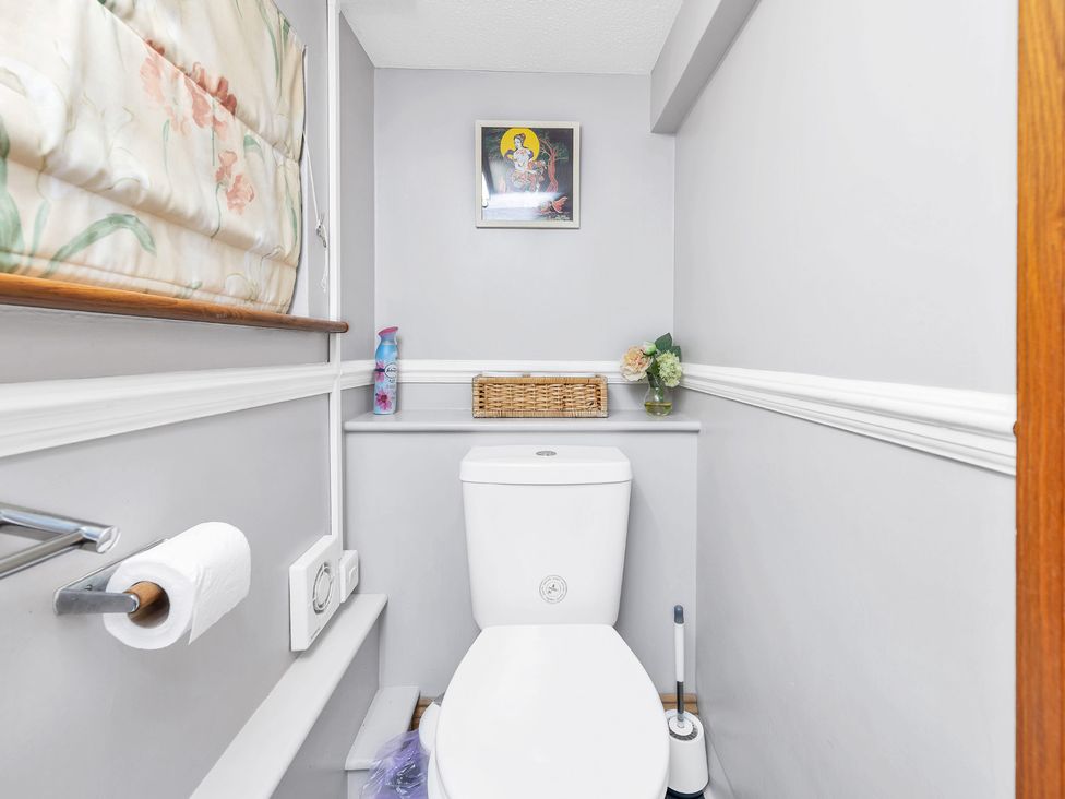 A bathroom featuring a white toilet and wall art at Oldfields