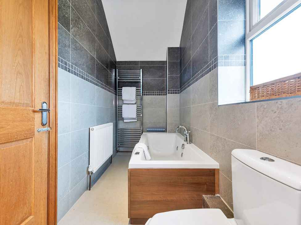 A bathroom with a bath tub and toilet at Oldfields